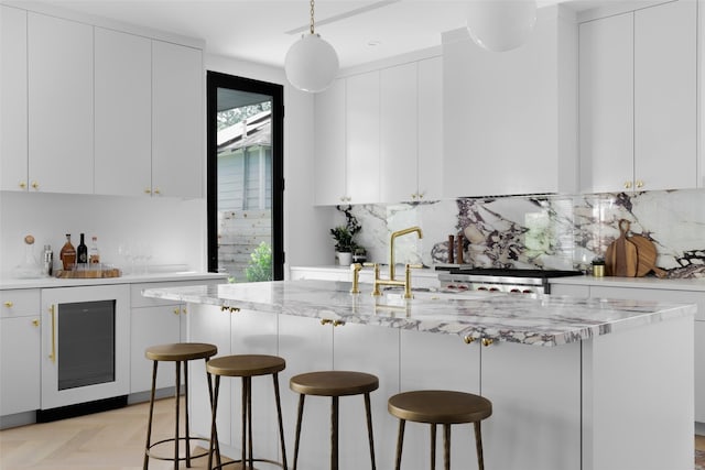 kitchen with a breakfast bar area, white cabinets, and light parquet floors