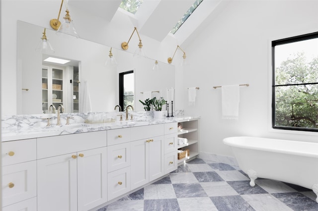 bathroom with vanity, lofted ceiling with skylight, and a washtub