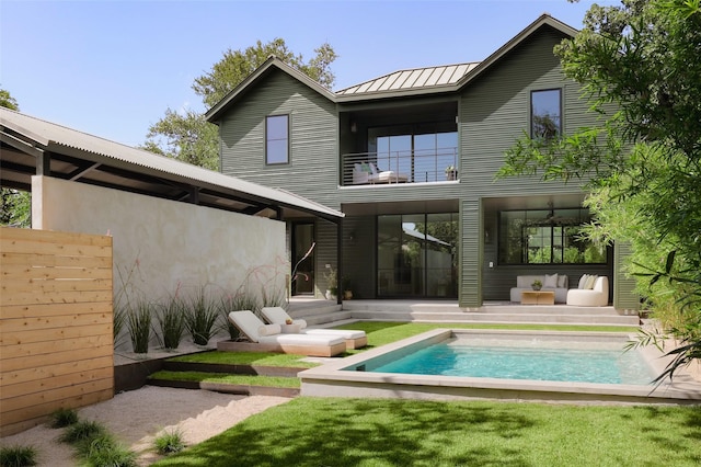 rear view of house with outdoor lounge area and a balcony