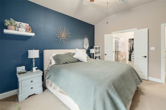 carpeted bedroom with ensuite bathroom, a spacious closet, and lofted ceiling