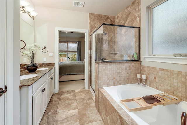 bathroom featuring separate shower and tub, vanity, and plenty of natural light