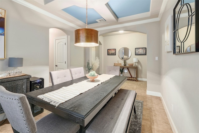 tiled dining room with beam ceiling, ornamental molding, a raised ceiling, and coffered ceiling