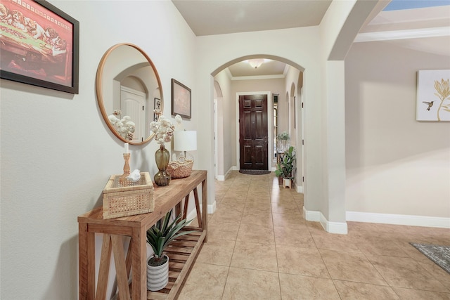 hallway with light tile patterned floors and ornamental molding