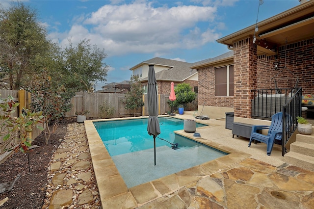 view of swimming pool with a patio, a fenced backyard, and a fenced in pool