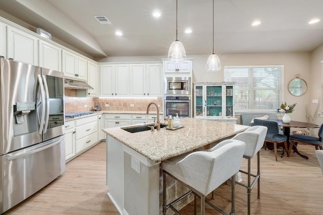 4408 Trinity Woods St, Leander, TX 78641 - kitchen with appliances with stainless steel finishes, a sink, under cabinet range hood, decorative backsplash, and white cabinetry