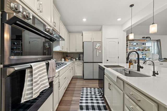 kitchen featuring a sink, light countertops, backsplash, and stainless steel appliances