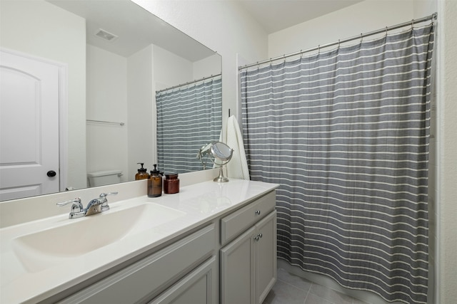 bathroom featuring toilet, vanity, and tile patterned flooring