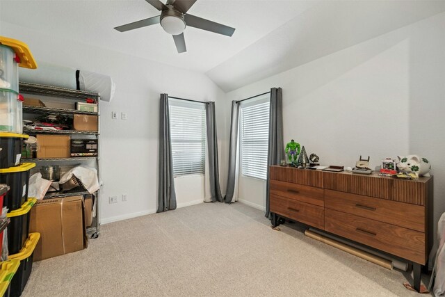 interior space featuring baseboards, lofted ceiling, light colored carpet, and ceiling fan