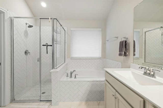 bathroom with a bath, a shower stall, vanity, and vaulted ceiling