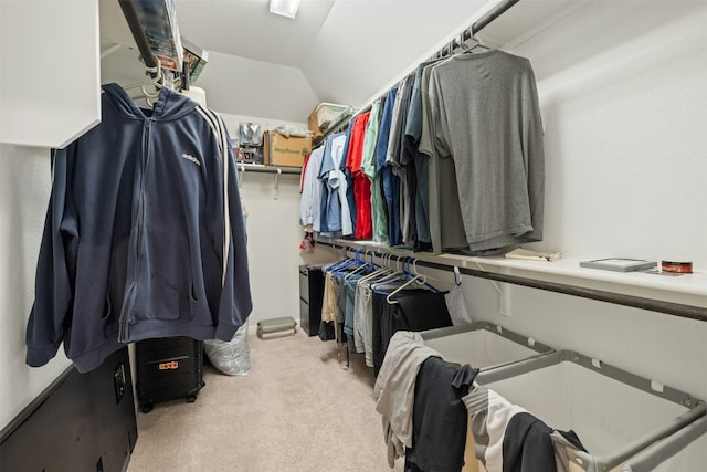 walk in closet with lofted ceiling and carpet