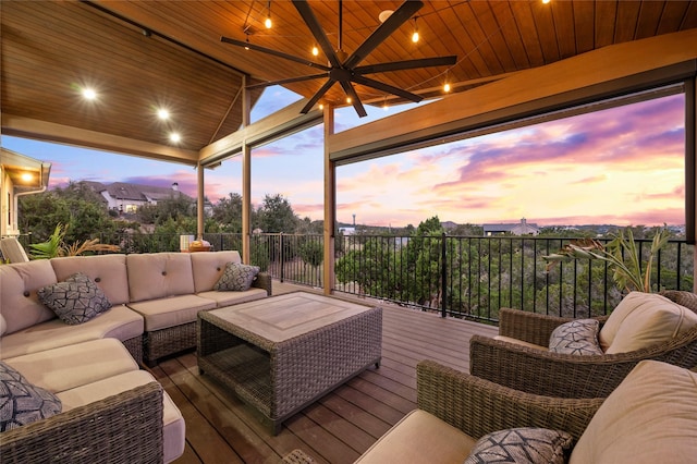 deck at dusk with ceiling fan and an outdoor hangout area