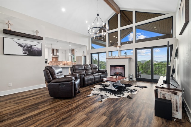 living room with hardwood / wood-style floors, a notable chandelier, plenty of natural light, and high vaulted ceiling