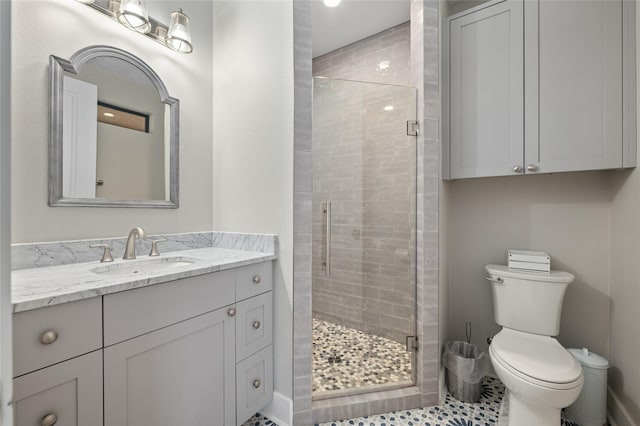 bathroom with vanity, a shower with shower door, and toilet