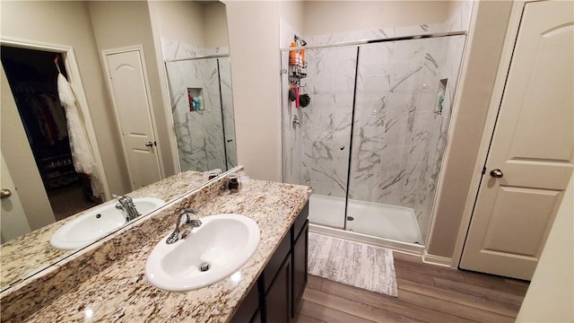 bathroom with a shower with shower door and vanity