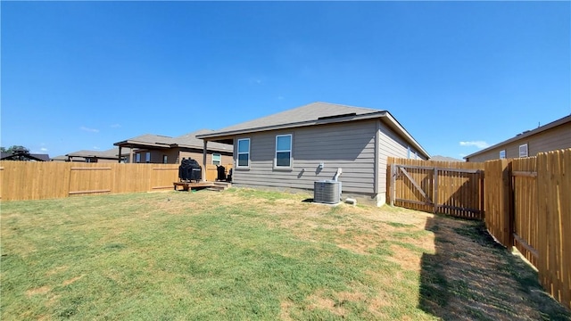 back of house with a lawn and central air condition unit