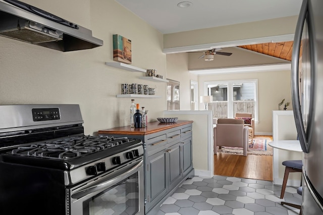 kitchen with vaulted ceiling, appliances with stainless steel finishes, range hood, gray cabinetry, and ceiling fan