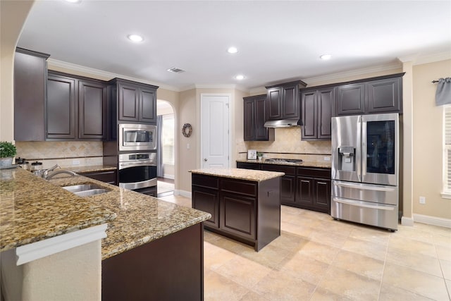 kitchen featuring a center island, sink, stainless steel appliances, and dark brown cabinetry