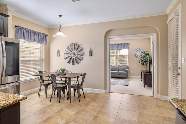 tiled dining area featuring a wealth of natural light and crown molding