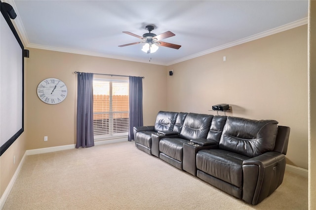 home theater featuring ceiling fan, light colored carpet, and ornamental molding