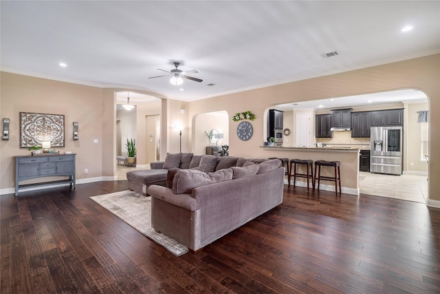 living room with ceiling fan, dark hardwood / wood-style flooring, and crown molding