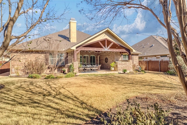 back of property with a yard and a patio