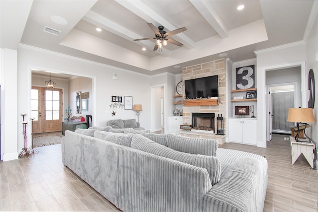 living room featuring ceiling fan, a tray ceiling, french doors, and a fireplace