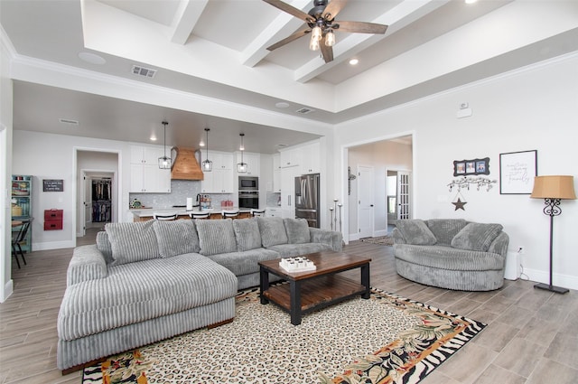 living room featuring ceiling fan, a towering ceiling, and beamed ceiling