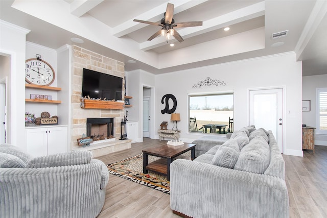 living room with ceiling fan and a stone fireplace