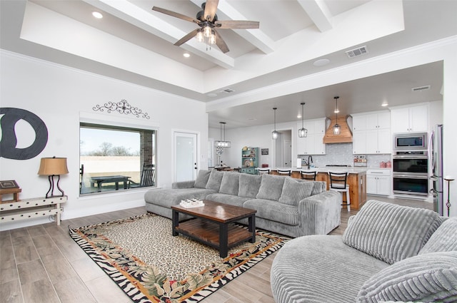 living room featuring ceiling fan and beamed ceiling