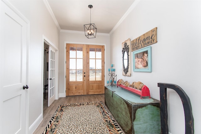 doorway with wood-type flooring, ornamental molding, french doors, and an inviting chandelier