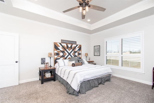 carpeted bedroom featuring ceiling fan, a tray ceiling, and ornamental molding