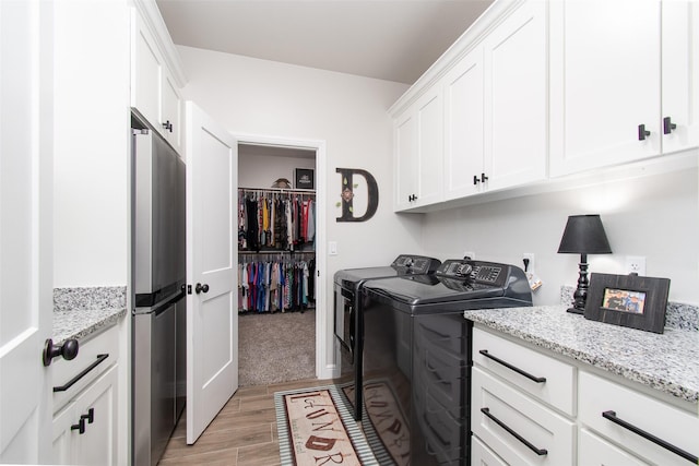 laundry area featuring separate washer and dryer and cabinets