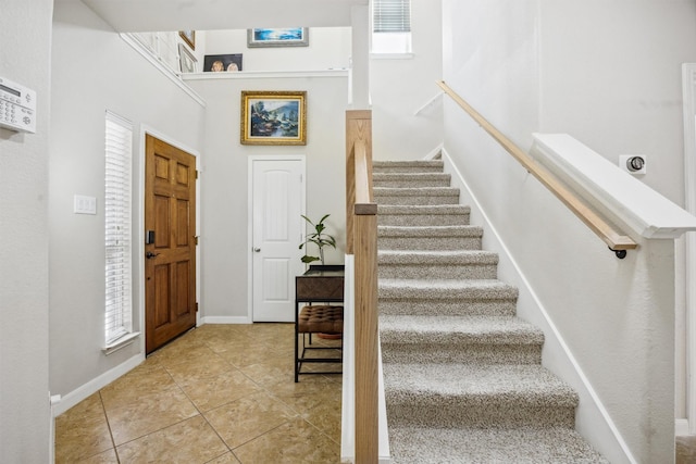 tiled foyer entrance with a towering ceiling