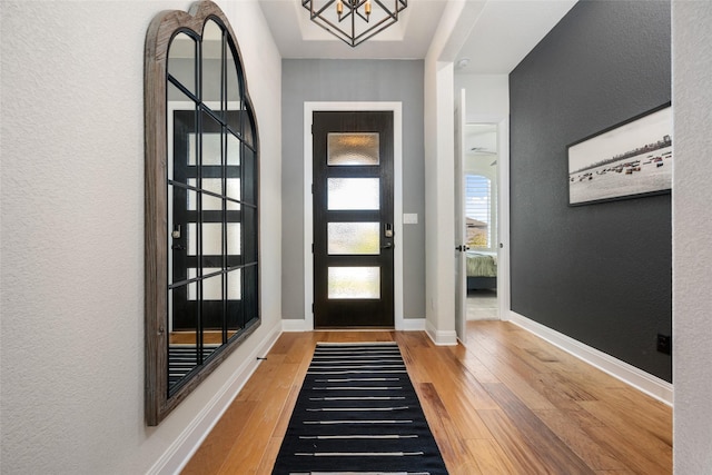 foyer featuring wood-type flooring and a notable chandelier