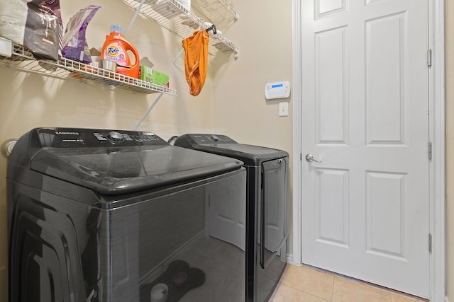 laundry room with light tile patterned flooring and washer and clothes dryer