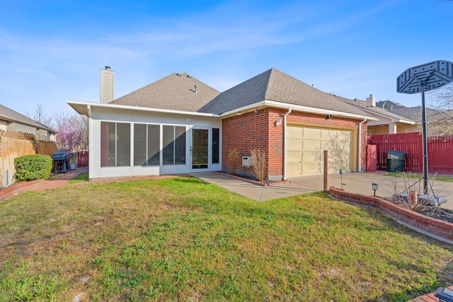 back of house with a sunroom, a yard, and a garage