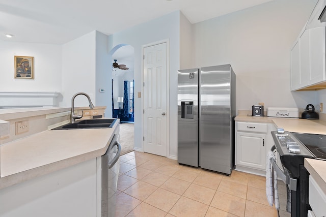 kitchen featuring light tile patterned floors, stainless steel appliances, white cabinets, and sink