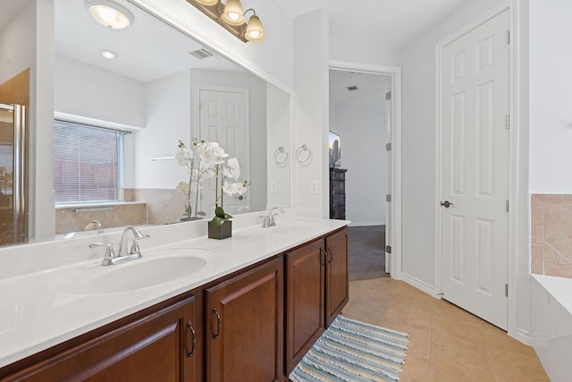 bathroom with tile patterned flooring, a bathtub, and vanity