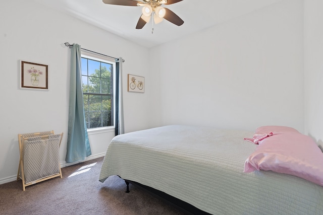 bedroom with ceiling fan, dark carpet, and multiple windows