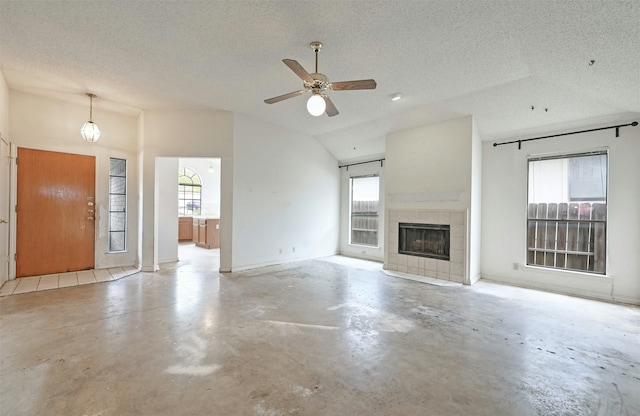 unfurnished living room with a textured ceiling, lofted ceiling, and a tile fireplace