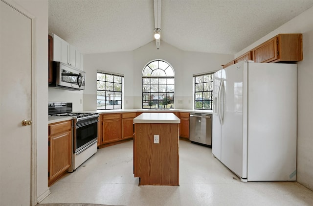 kitchen with a textured ceiling, lofted ceiling, stainless steel appliances, and a kitchen island