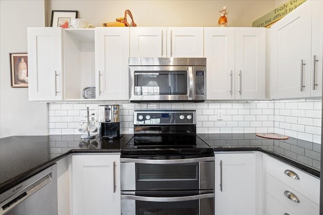 kitchen featuring stainless steel appliances, decorative backsplash, dark stone countertops, and white cabinets