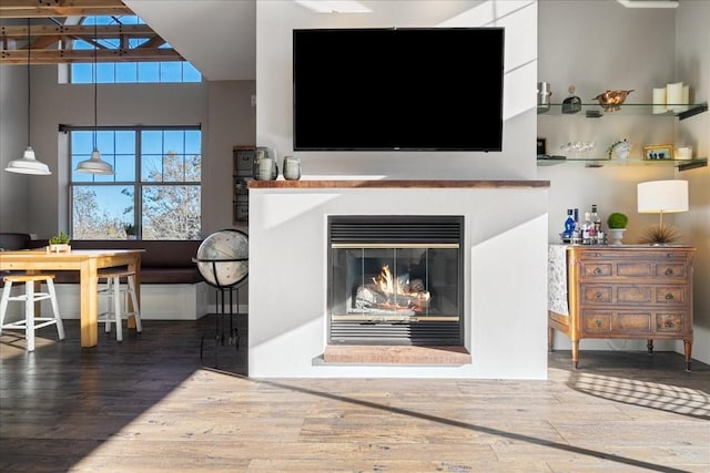 living room with wood-type flooring and a towering ceiling