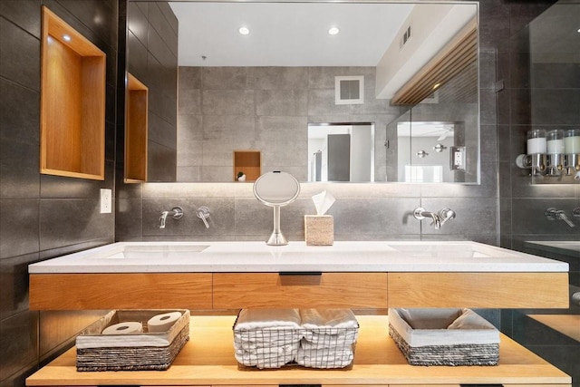 bathroom with vanity, tile walls, and backsplash