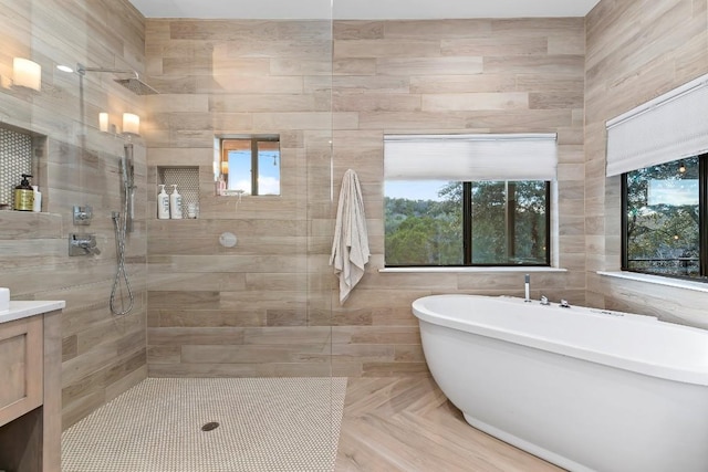 bathroom featuring vanity, separate shower and tub, and a healthy amount of sunlight