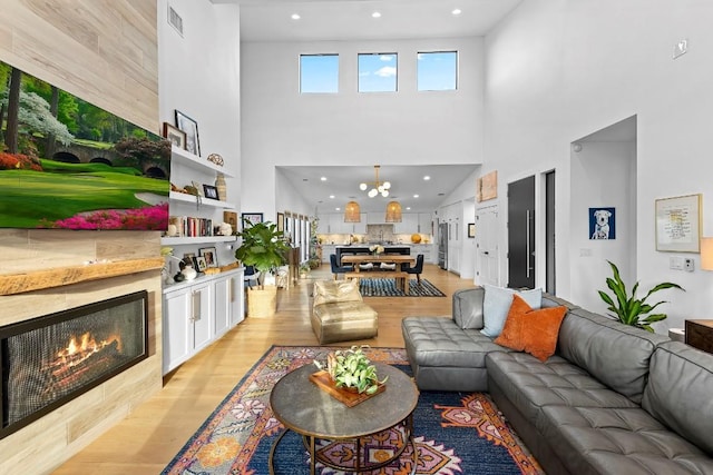 living room featuring a tiled fireplace and light wood-type flooring