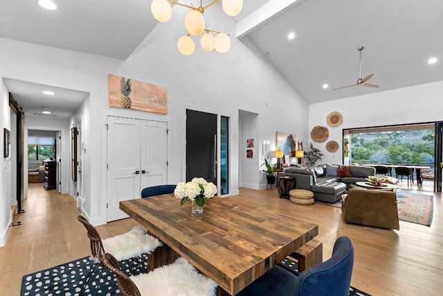 dining area with high vaulted ceiling, a wealth of natural light, and light hardwood / wood-style floors