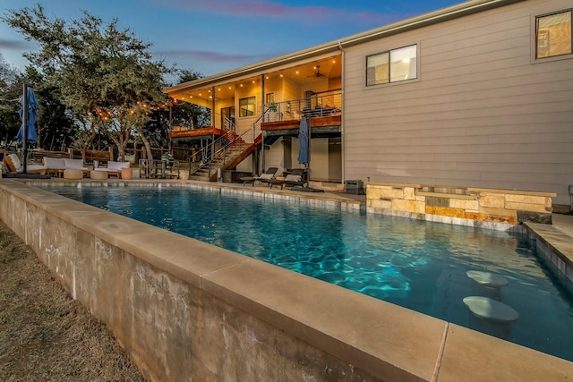 pool at dusk featuring a patio