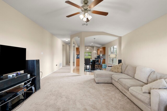 living room featuring ceiling fan, light carpet, and vaulted ceiling