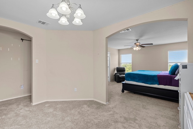 bedroom featuring light carpet and ceiling fan with notable chandelier